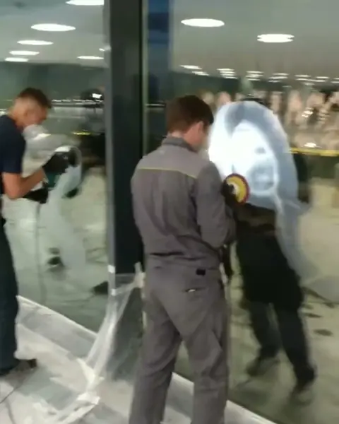 Мастера полируют стеклянную перегородку в лобби бизнес-центра